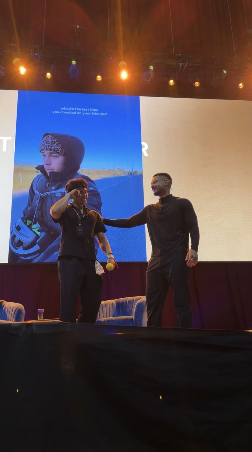 Lumore and Steven Bartlett on stage in front of a giant photo of Lumore on his ride